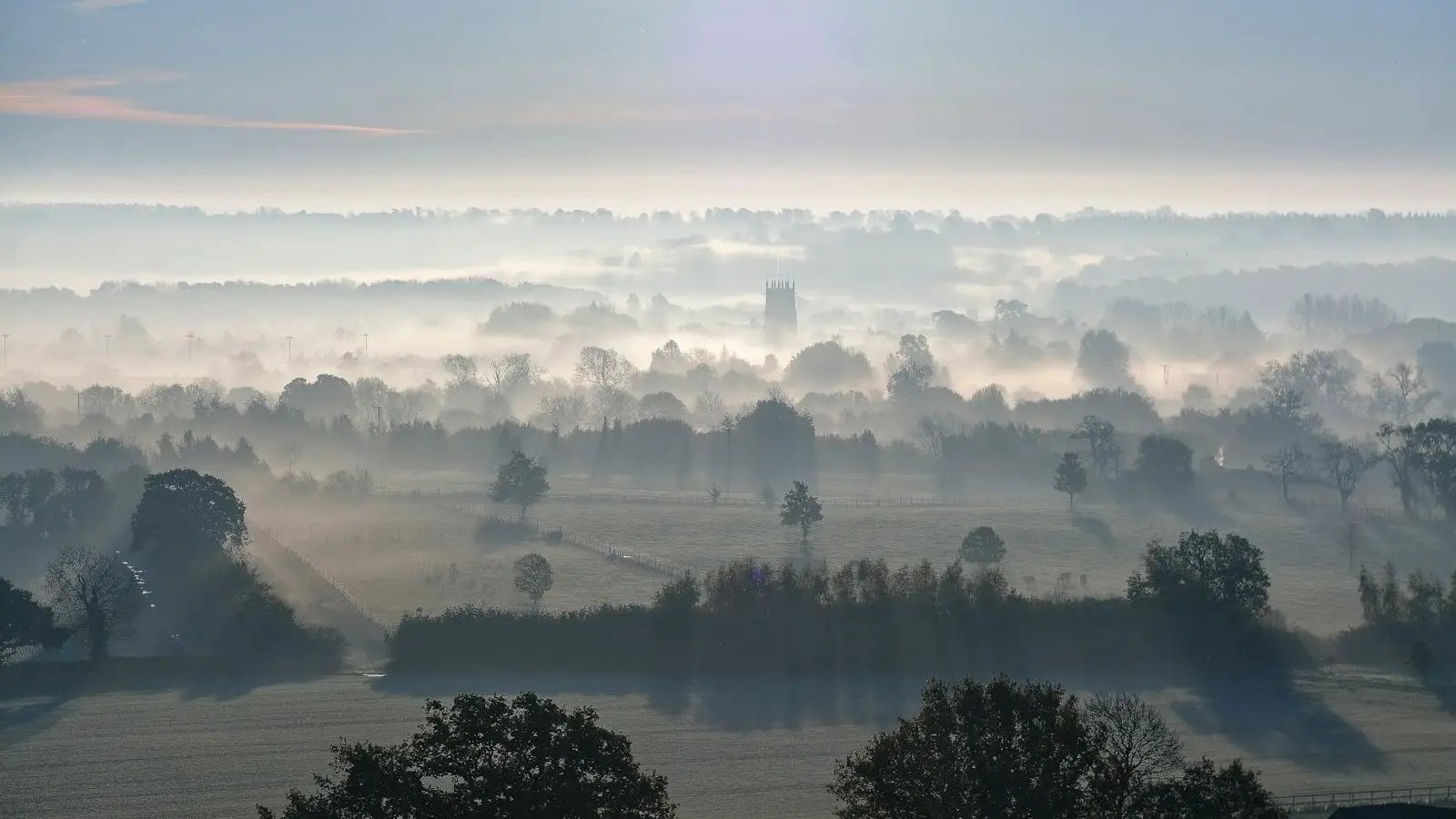 Mist lying over an English valley at sunrise on a clear winter morning